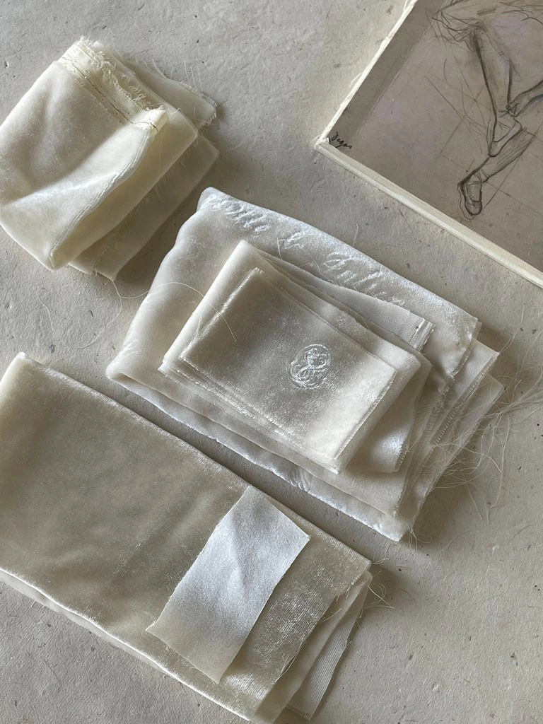 Stacked folded white linens on a brass housekeeping cart